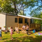 Terrasse ombragée avec famille et pelouse devant le mobil-home 35m² avec Terrasse Saint-Gérons API-1-52-1314