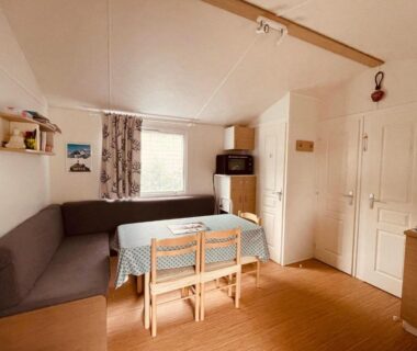 Intérieur salon avec canapé d'angle et table à manger du Mobil-home 3ch le Per Malou Camping Les Clarines
