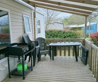 Terrasse couverte avec table chaises et barbecue du Mobil home