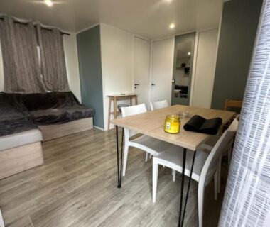 Intérieur avec coin repas et canapé dans le mobil-home