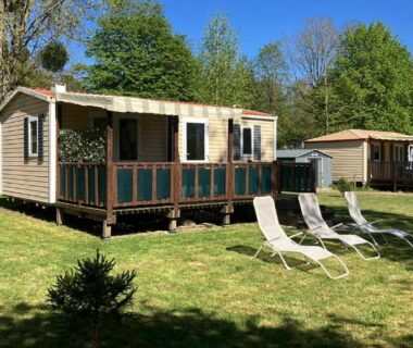 Pelouse et chaises longues devant mobil-home au Camping de Bairon 08 en bord de lac