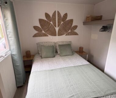 Chambre avec lit double et décor mural dans le mobil home 4-6 personnes à Messanges