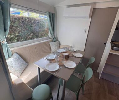 Intérieur coin repas avec table dressée dans le mobil home 4-6 personnes à Messanges