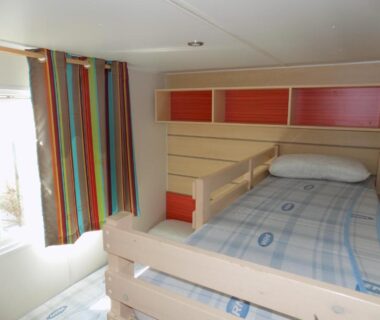 Cabine avec lits superposés et rideaux colorés dans le Mobil home 4/6 personnes du camping PORT LA NOUVELLE