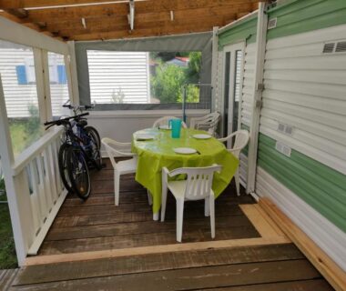 Terrasse couverte avec table ronde, chaises et vélos du Mobil home 4 couchages