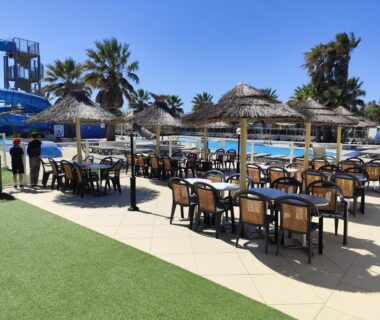 Espace piscine avec parasols et tables du mobil-home 4 personnes au camping Marisol
