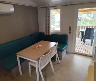 Séjour avec table et banquette dans le mobil-home 4 personnes clim au camping Marisol