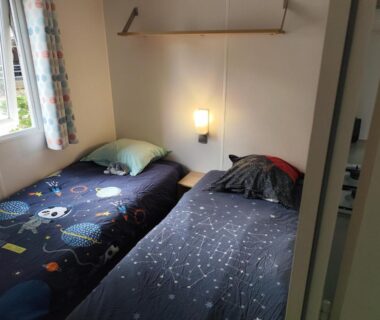 Chambre avec deux lits simples et lampe dans le mobil-home 4 personnes clim du camping Marisol