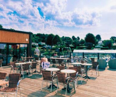 Terrasse en bois avec tables et chaises du Mobil-home 4 personnes dans camping 5 étoiles proche de la mer