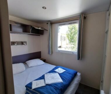 Chambre avec lit double et fenêtre dans le mobil home 4 personnes