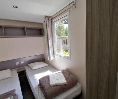 Chambre avec deux lits simples et serviettes dans le mobil home 4 personnes Carnac