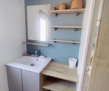 Salle d'eau avec lavabo miroir et étagères dans le mobil home 40 m2 camping 4*