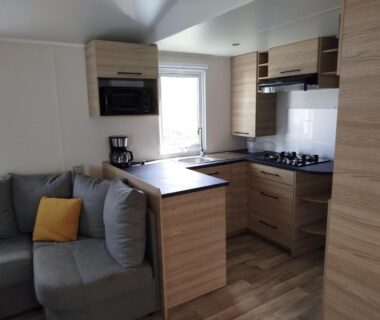 Intérieur avec cuisine équipée et coin salon dans le Mobil-home 40m2