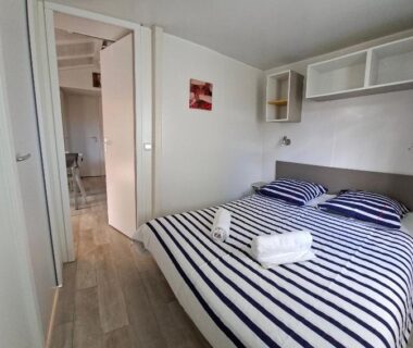 Chambre avec lit double et serviettes dans le Mobil-home 447 au camping Siblu 4 étoiles