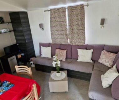 Intérieur salon avec canapé et table dans le Mobil-home 447 3 chambres camping Siblu 4 étoiles