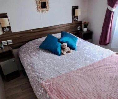 Chambre avec lit double et peluche dans le mobil home