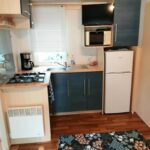Coin cuisine avec réfrigérateur micro-ondes et plaque de cuisson dans le Mobil home 5 pers proche d'Europa Park E020