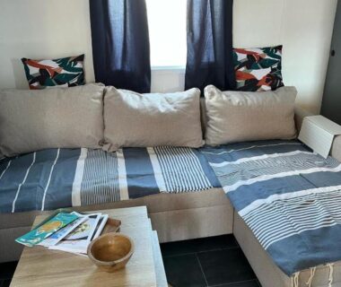 Coin salon avec canapé coussins et table basse dans le Mobil-home 5 personnes