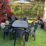 Terrasse avec table parasol et six chaises au mobil-home 5 personnes