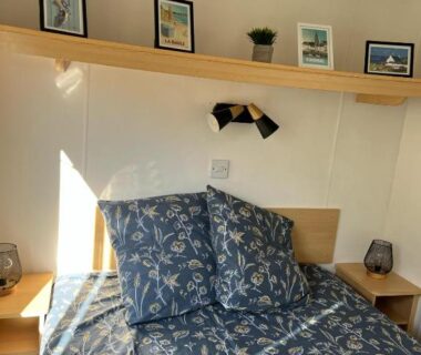 Intérieur chambre avec lit coussins et étagères dans le Mobil-home 5 personnes
