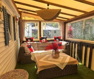 Véranda aménagée avec banquette et table dans le mobil-home 5 personnes à louer