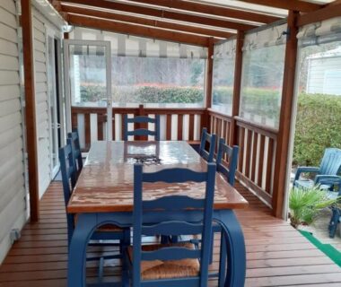 Terrasse couverte en bois avec table et chaises du Mobil home 502 Gastes