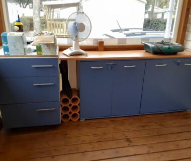 Coin cuisine avec meubles bleus et ventilateur du Mobil home 502 Gastes