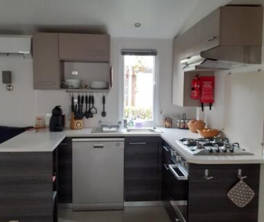 Cuisine équipée avec plaque de cuisson, évier et lave-vaisselle dans le Mobil home 502 Gastes