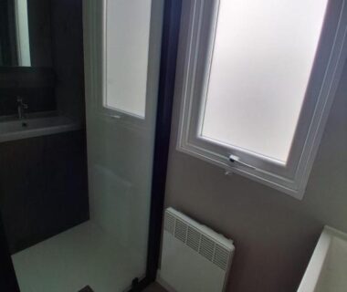 Salle de bain avec cabine de douche et fenêtre dans le Mobil home 590
