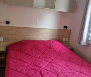 Chambre avec lit double et rangements dans le mobil-home du Camping Les Sables d'Or