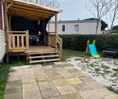 Terrasse couverte en bois avec toboggan pour enfants du mobil home 6-8pers Le lac des rêves