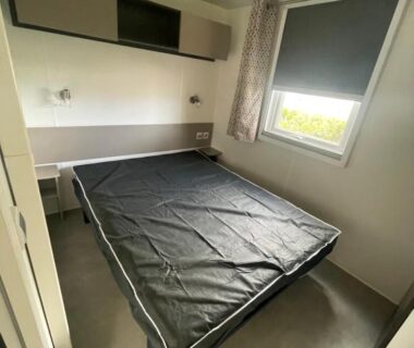 Chambre avec lit double et fenêtre dans le mobil home Le lac des rêves