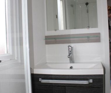 Salle de bain avec lavabo meuble et miroir dans le mobil-home