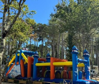 Aire de jeux gonflable dans le camping entourée de pins près du Mobil home 6 à 8 personnes