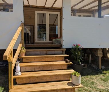 Terrasse surélevée avec escalier en bois menant à l'entrée du mobil home 6 à 8 personnes climatisé