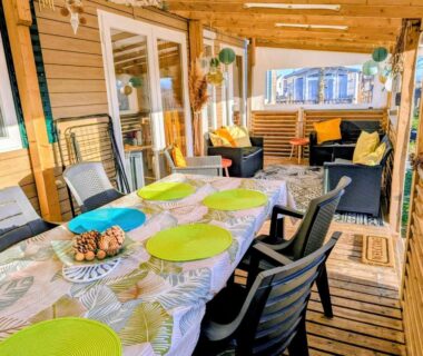 Terrasse couverte avec table chaises et salon extérieur du mobil home 6 à 8 personnes climatisé