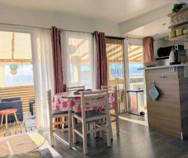 Intérieur avec coin repas et kitchenette du Mobil home 6 à 8 personnes climatisé
