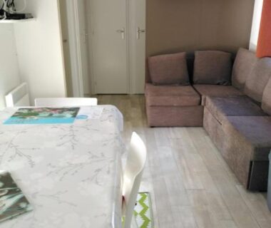 Coin repas et salon avec canapé dans le Mobil home 6 à 8pers FUN PASS NON INCLUS