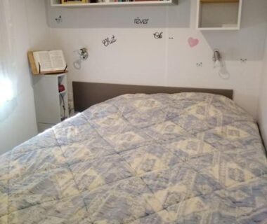 Chambre avec lit double et étagères dans le mobil home 6 à 8pers FUN PASS NON INCLUS