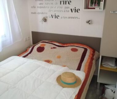 Chambre avec lit double couette et étagères dans le Mobil home 6 à 8pers FUN PASS NON INCLUS