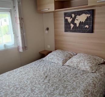 Chambre avec lit double et rangements dans le Mobil-home 6 couchages