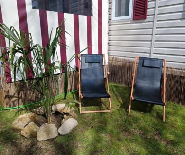 Devant le mobil-home deux chaises longues sur la pelouse Mobil-home 6 couchages