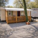 Emplacement ombragé avec terrasse en bois et arbre du Mobil-home 6 pers Climatisé avec piscines
