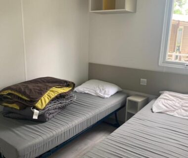 Intérieur avec deux lits et fenêtre dans le Mobil home 6 pers camping 5