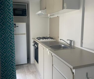 Cuisine compacte avec évier, plaques, four et réfrigérateur du mobil home 6 pers camping 5