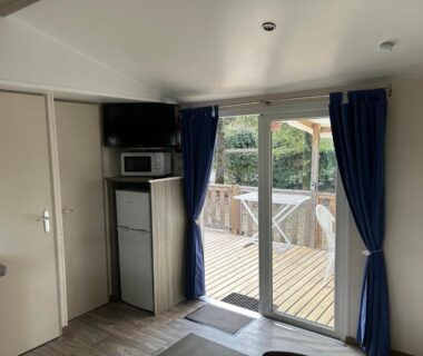 Intérieur avec baie vitrée et terrasse en bois du Mobil-home 6 pers proche Puy duFou