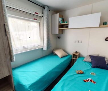 Chambre avec deux lits simples et fenêtre dans le Mobil-home 6 pers tout confort Clim