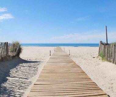 Plage avec passerelle en bois menant à la mer depuis le Mobil-home 6 pers tout confort Clim piscine et animations