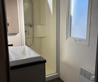 Salle de bain avec douche cabine lavabo et fenêtre dans le Mobil home 6 personnes
