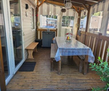 Terrasse couverte avec table et bancs du mobil home 6 personnes